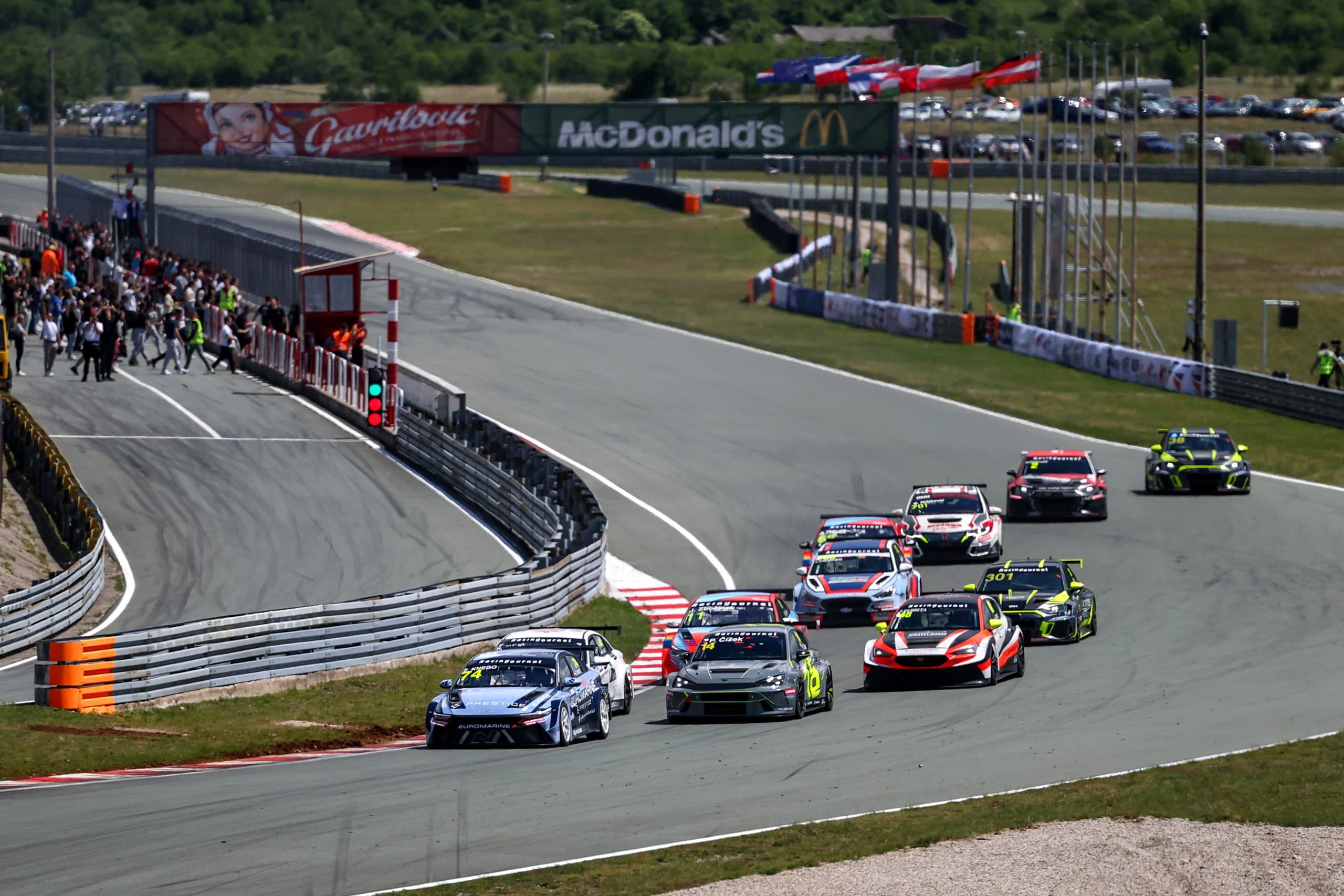 The TCR field through the first corner at Grobnik, spectators at the fence